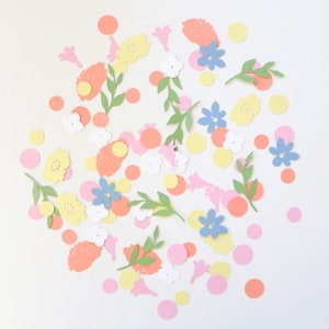 Puede incluir: Una colecci&oacute;n de recortes de papel coloridos, que incluyen flores, hojas y c&iacute;rculos. Las flores son de color amarillo, azul y blanco, con hojas verdes y c&iacute;rculos rosas, naranjas y amarillos. Los recortes est&aacute;n esparcidos sobre un fondo blanco.