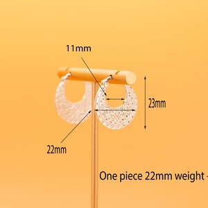 Peut inclure: Une paire de cr&eacute;oles argent&eacute;es avec un motif g&eacute;om&eacute;trique textur&eacute;. Les boucles d'oreilles mesurent 23 mm de hauteur et 22 mm de largeur, avec un diam&egrave;tre int&eacute;rieur de 11 mm. Chaque boucle p&egrave;se 3,5 grammes, comme indiqu&eacute; sur l'image.