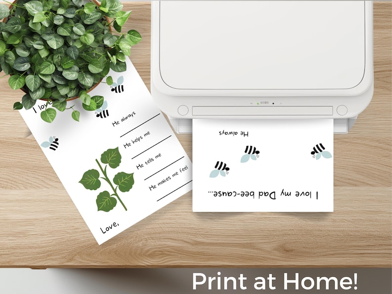 Puede incluir: Una impresora imprime una hoja de papel blanca con el texto "I love my Dad bee-cause..." e ilustraciones de abejas. Otra hoja de papel con ilustraciones de abejas y el texto "I love" est&aacute; junto a una planta en maceta. El texto "Print at Home!" est&aacute; en la parte inferior.