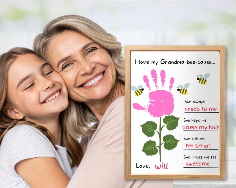 May include: A framed print with the text "I love my Grandma bee-cause..." featuring a pink handprint flower design, bees, and the words "reads to me", "brush my hair", "I'm smart", and "awesome". The print is signed "Love, Will".