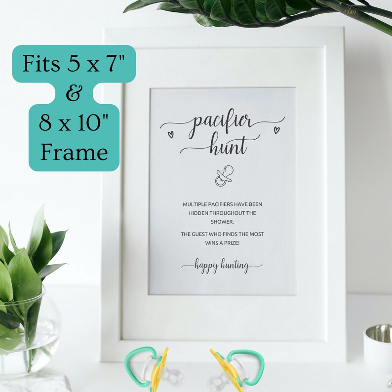 Pode incluir: Uma placa emoldurada branca com o texto "pacifier hunt" e um gr&aacute;fico de chupeta, projetada para um jogo de ch&aacute; de beb&ecirc;. A moldura serve para molduras de 12,7 x 17,8 cm e 20,3 x 25,4 cm. Duas chupetas com cabos verdes est&atilde;o em primeiro plano.