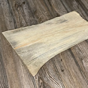May include: A light brown wood plank with a slightly curved shape and a natural wood grain pattern.