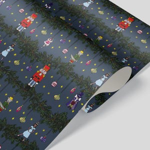 May include: Dark blue wrapping paper featuring a repeating pattern of Christmas ornaments, nutcrackers, and characters from The Nutcracker ballet. The design includes green garland and yellow stars.