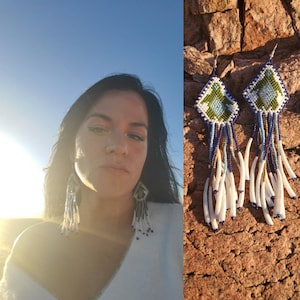 May include: A pair of beaded earrings with a geometric design in shades of blue, green, and white. The earrings feature a long fringe of white beads and blue beads.