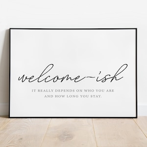 Puede incluir: Una impresión enmarcada en blanco y negro con el texto "welcome-ish" y la leyenda "IT REALLY DEPENDS ON WHO YOU ARE AND HOW LONG YOU STAY."