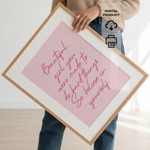 May include: A framed print with a pink background and the words "Beautiful girl, you were made to do hard things. So believe in yourself" in a cursive font. The frame is light brown.