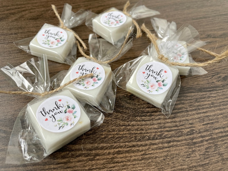 May include: Five small white soap bars wrapped in clear cellophane bags with twine and a floral thank you sticker.