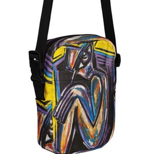 May include: A black crossbody bag with a colorful abstract art print. The art features a figure with yellow, purple, blue, and orange brushstrokes. The bag has a black adjustable strap and a black buckle.