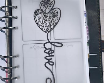 May include: A translucent vellum dashboard for a ring-bound planner featuring a black line art illustration of a heart filled with floral patterns and leaves, with the word love written in a cursive script extending downward from the heart.
