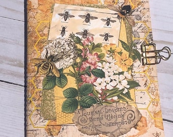 May include: A yellow and brown journal with a honeycomb pattern and a floral design. The journal has a title that reads "A Journal Devoted to Bees Honey and Home Interests".