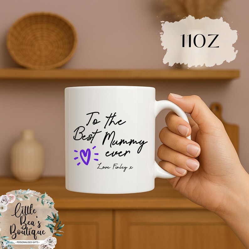 May include: White ceramic mug with the text "To the Best Mummy ever" in black script, a purple heart, and the name "Love Finley x". The mug is 11 oz.