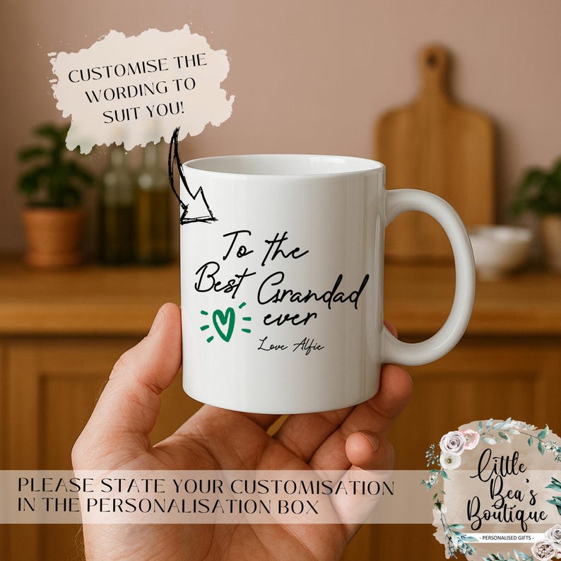 May include: White ceramic mug with the text "To the Best Grandad ever" in black script, a green heart, and "Love Alfie." The mug also has the text "CUSTOMISE THE WORDING TO SUIT YOU!" and "PLEASE STATE YOUR CUSTOMISATION IN THE PERSONALISATION BOX."