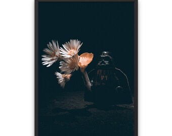 May include: A dark, shadowy figure resembling Darth Vader stands against a black background, with a bouquet of white and orange flowers in front of it.