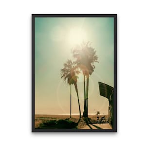 Könnte beinhalten: Ein Foto von drei Palmen, die sich vor einem strahlend sonnigen Himmel abzeichnen. Die Sonne scheint hell und erzeugt einen Linsenflare-Effekt. Der Strand ist im Vordergrund zu sehen, mit einem Rettungsschwimmerstand in der Ferne.