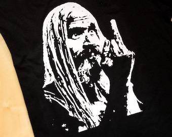 May include: Black t-shirt with a white graphic print of a man with long hair and a beard giving the middle finger.