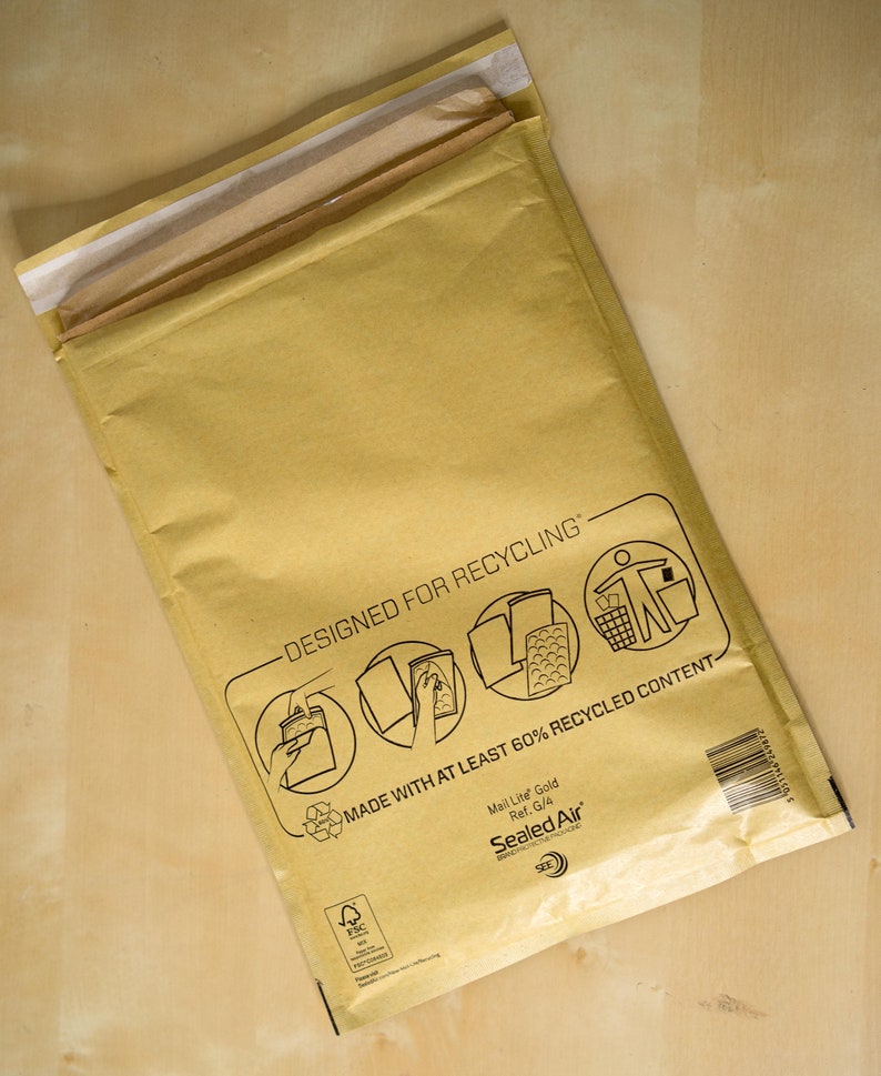 Op de afbeelding: Een bruine papieren verzend envelop met de tekst "Designed for Recycling" en "Made with at least 60% recycled content". De envelop is gelabeld met "Mail Lite Gold" en "Sealed Air".