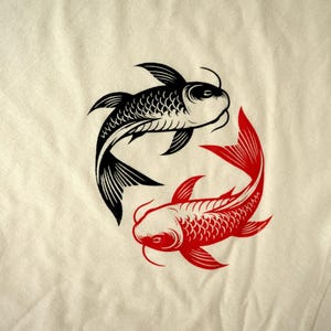 K&ouml;nnte beinhalten: Ein cremefarbener Stoff zeigt ein Design mit schwarzen und roten Koi-Fischen. Die Fische sind in einem kreisf&ouml;rmigen Yin-Yang-Muster angeordnet, mit einem schwarzen und einem roten Fisch. Das Design ist eine stilisierte Illustration.