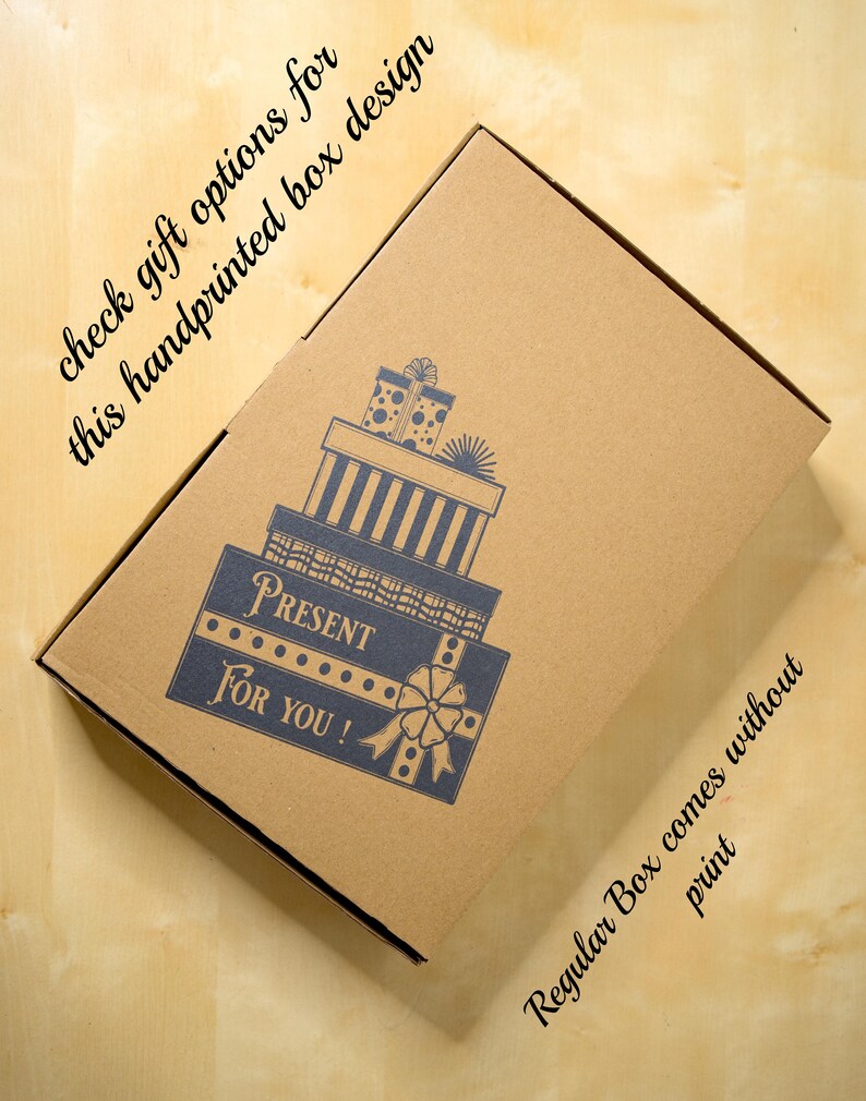 May include: A brown cardboard box with a hand-printed design of a stack of presents. The design includes the words "Present" and "For You!" The box is on a light wood surface. The text "Regular Box comes without print" is visible on the bottom right corner of the box.