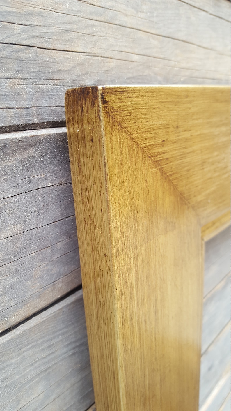 Peut inclure: Gros plan sur le coin d'un cadre photo en bois. Le cadre est de couleur brun clair avec une finition vieillie.