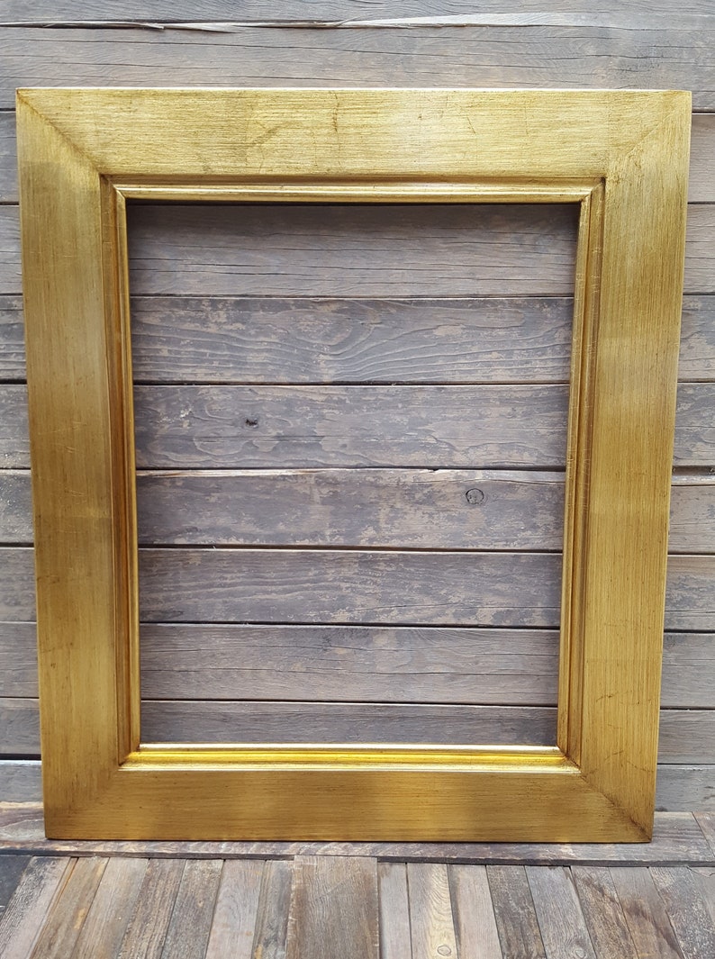 Peut inclure: Un cadre photo rectangulaire de couleur dor&eacute;e. Le cadre est en bois et a une finition lisse et polie.