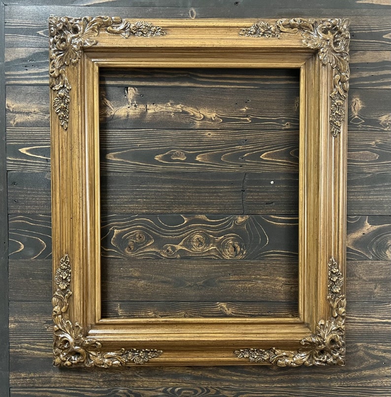 May include: A gold-toned ornate picture frame with a woodgrain background.