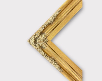 Può includere: Una cornice dorata con dettagli decorativi attorno ai bordi. La cornice è in legno e ha una finitura lucida.