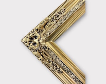 May include: A gold picture frame with ornate detailing. The frame has a raised, textured design with a floral motif.