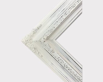 May include: White ornate picture frame with a distressed finish. The frame has a decorative, raised design around the edges.