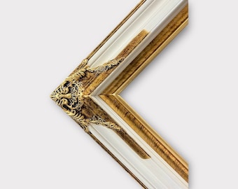 May include: A white and gold picture frame with ornate detailing. The frame has a wide, flat molding with a raised lip and a decorative corner.