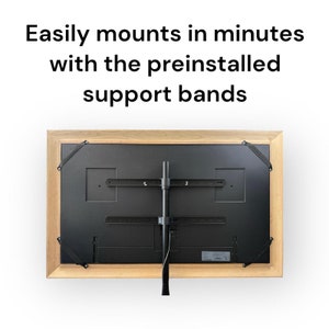 May include: The back of a wooden framed television with a black stand attached. The stand is mounted to the wall and has two black support bands on each side of the television.