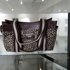 Bolso de mano Tommy Hilfiger para mujer, color marrón tostado, con estampado de letras y detalles de cuero.