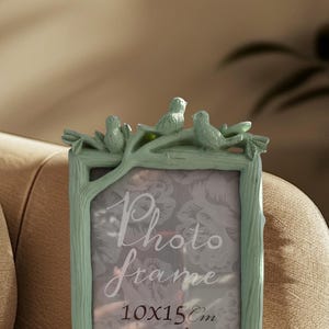 May include: A mint green photo frame with a tree branch design and three small bird figurines. The frame is sized at 4x6 inches and features the words "Photo frame" in elegant script.
