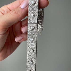 K&ouml;nnte beinhalten: Ein silbernes Armband mit geometrischem Design, besetzt mit funkelnden Diamanten.