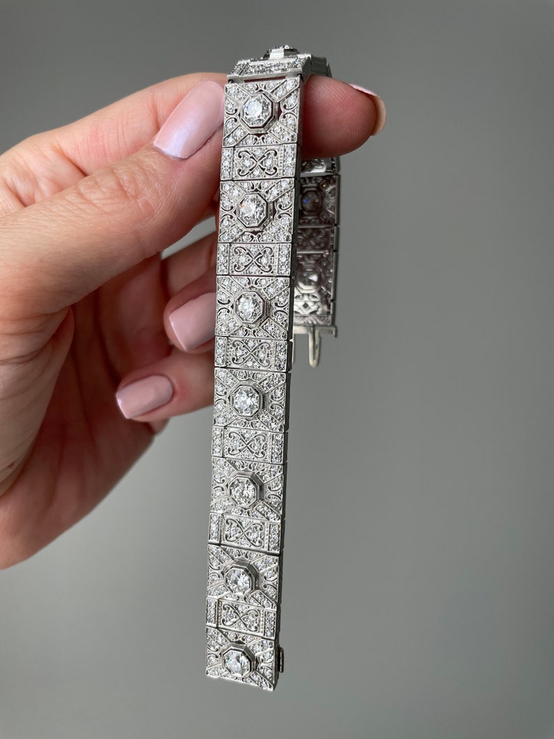 K&ouml;nnte beinhalten: Ein silbernes Armband mit geometrischem Design, besetzt mit funkelnden Diamanten.