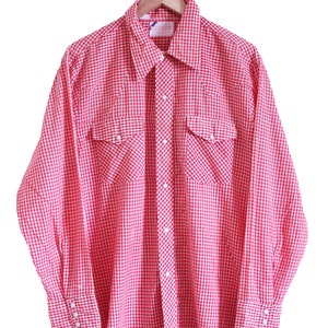 May include: A red and white gingham long-sleeve button-down shirt with two chest pockets and a wooden hanger.