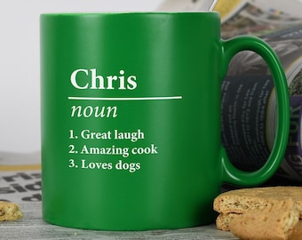 May include: Green ceramic mug with a white inscription that reads "Chris noun 1. Great laugh 2. Amazing cook 3. Loves dogs".