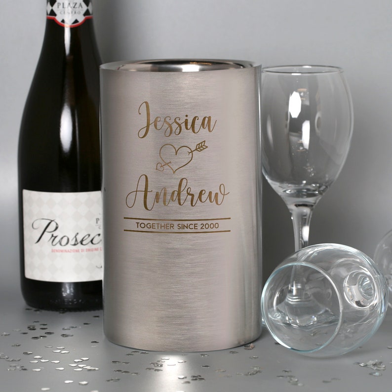 Puede incluir: Un enfriador de vino de acero inoxidable plateado con una inscripci&oacute;n personalizada que dice "Jessica & Andrew Together Since 2000" con un coraz&oacute;n y una flecha.