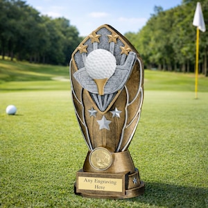 Puede incluir: Un trofeo de golf dorado y plateado, con una pelota de golf sobre un tee y un diseño de palo de golf. El trofeo está decorado con estrellas y tiene espacio para grabar. El texto "Any Engraving Here" es visible.