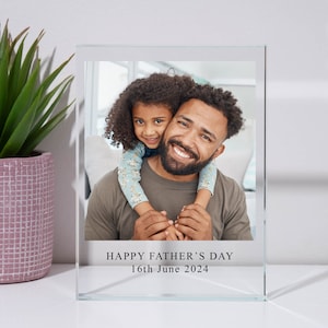 May include: A glass photo frame with a picture of a father and daughter. The frame has the text "HAPPY FATHER'S DAY 16th June 2024" printed on the bottom.