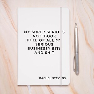 Puede incluir: Un cuaderno blanco con el texto "MY SUPER SERIOS NOTEBOOK FULL OF ALL MY SERIOUS BUSINESSY BITS AND SHIT" y el nombre "RACHEL STEV NS" en la parte inferior.