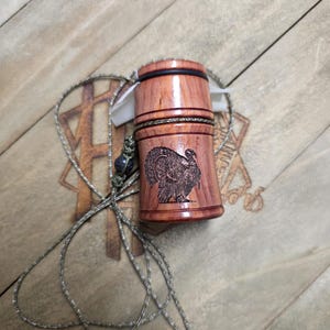 May include: A white ceramic mug with a black handle and the text "But First, Coffee" in a bold, black font. The mug is set against a blurred background, suggesting a cozy setting.