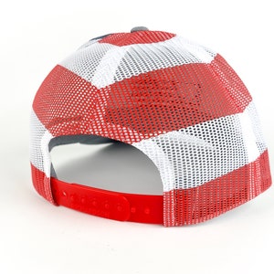 May include: A red, white, and blue trucker hat with a mesh back. The hat has a gray brim and a red strap.