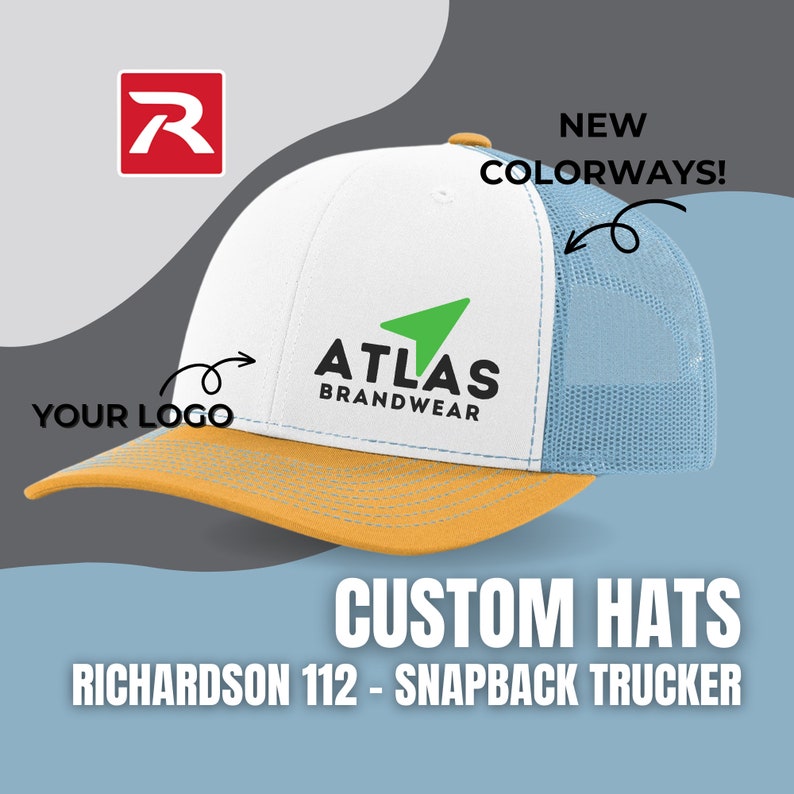 May include: White and blue trucker hat with a yellow brim. The hat has a green arrow logo with the text "ATLAS BRANDWEAR" on the front. The text "NEW COLORWAYS!" is written on the right side of the hat. The text "YOUR LOGO" is written on the left side of the hat.