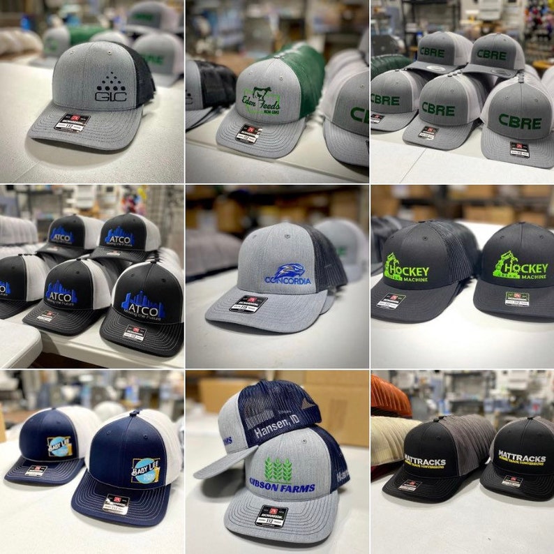 May include: A collection of 10 different embroidered baseball caps with various logos and designs. The caps are in a variety of colors, including gray, black, blue, and green. Some of the logos include "GIC", "Eden Feeds", "CBRE", "ATCO", "CONCORDIA", "Hansen, ID", "Gibson Farms", "Hockey Machine", and "Mattracks".