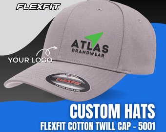 May include: A gray cotton twill cap with a green arrow logo and the text "ATLAS BRANDWEAR" embroidered on the front. The cap has a black Flexfit label on the back.