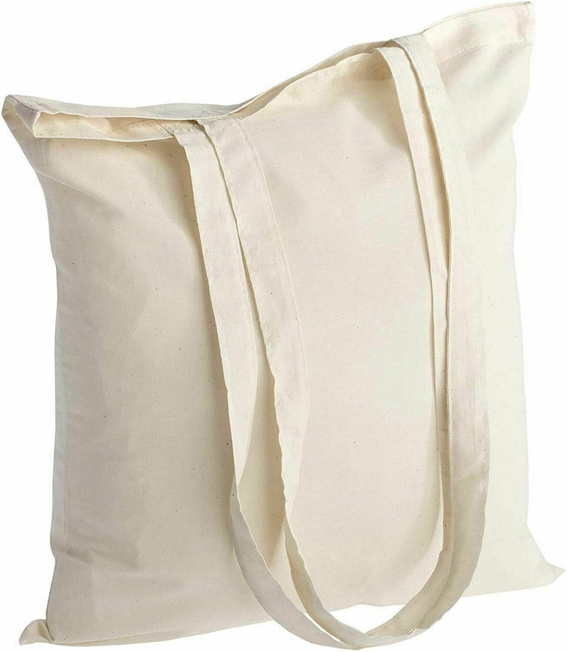 May include: A plain white canvas tote bag with two long handles. The bag is made of natural cotton and has a simple, unbleached look.