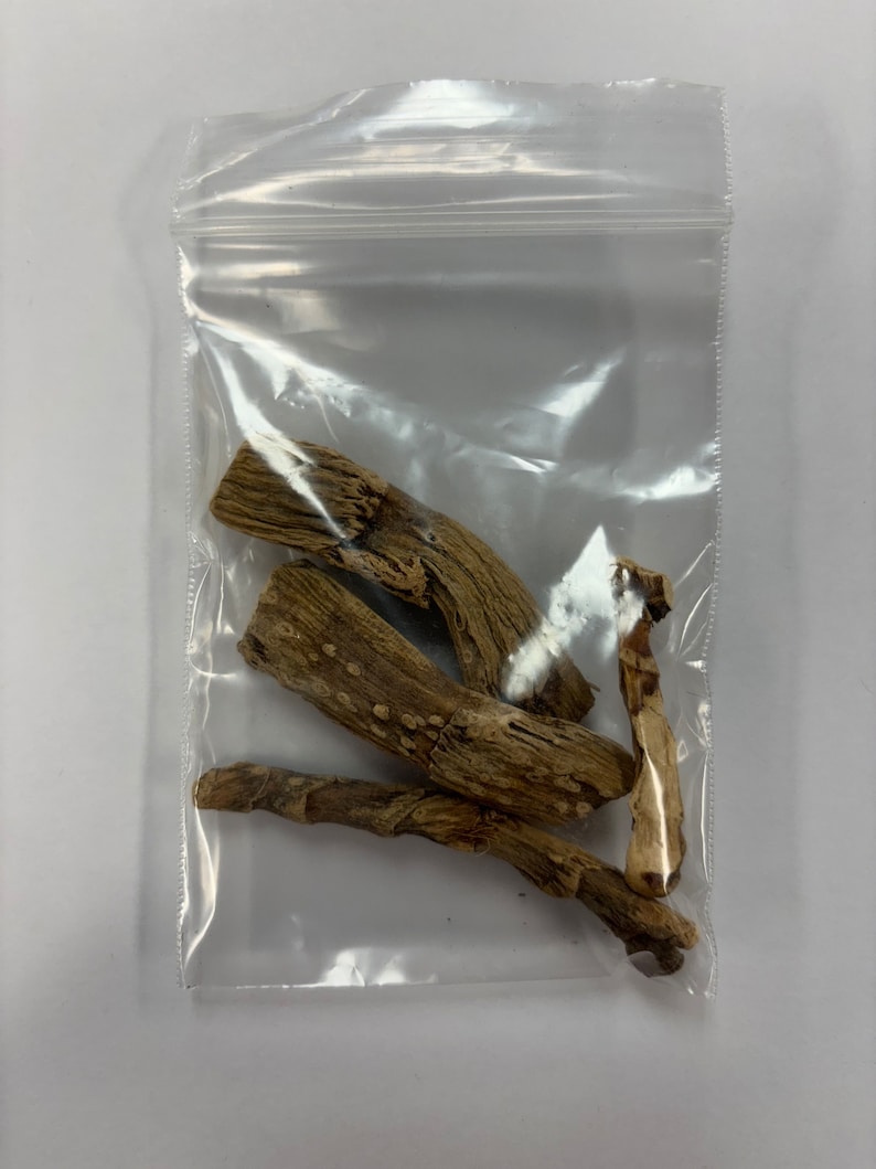 May include: A clear plastic bag containing several pieces of dried, light brown wood. The wood pieces have a rough, textured surface and varying shapes. The bag is sealed and sits against a white background.