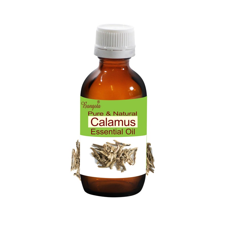 May include: A brown glass bottle with a white cap, labeled "Pure & Natural Calamus Essential Oil" with a green background and a picture of dried calamus root.