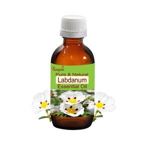 May include: A brown glass bottle with a white cap, labeled "Pure & Natural Labdanum Essential Oil." The label is green and white. White flowers with yellow centers are in the background. The bottle appears to hold approximately 4 fl oz.