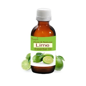Op de afbeelding: Een bruine glazen fles met een witte dop, met het label "Bangoia Pure & Natural Lime Essential Oil". De fles is omringd door groene limoenen.